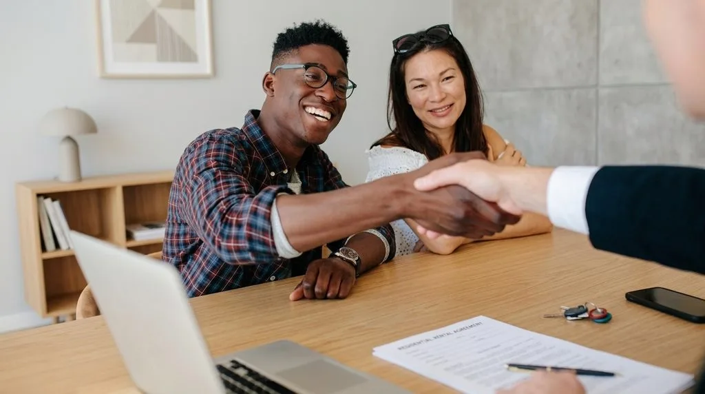 Two people shaking hands after signing a rental agreement