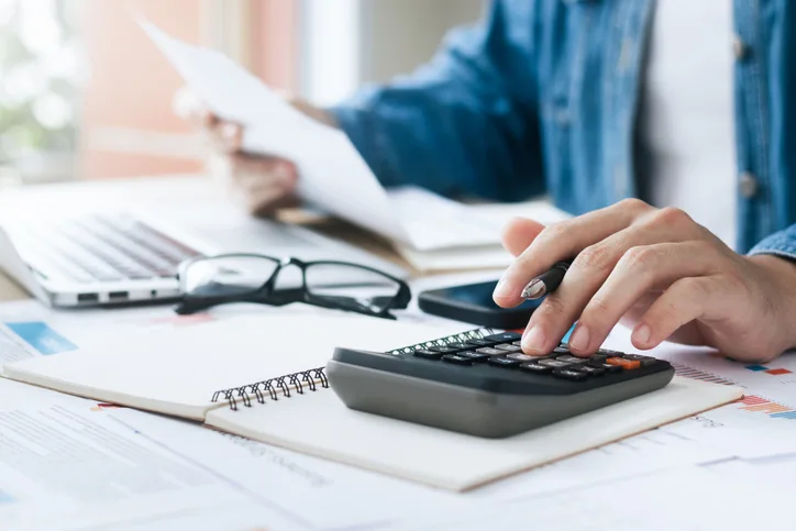 Mortgage documents with calculator on a desk during loan planning