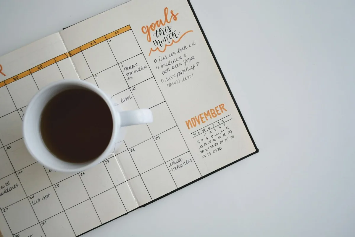 Calendar marked with annual bills next to a notebook budget