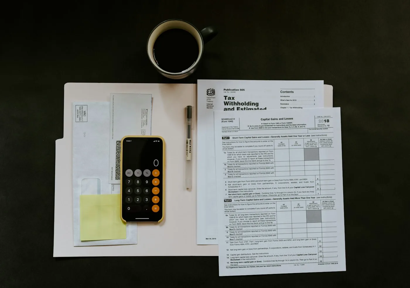 Desk with paycheck documents and a pen for planning automated debt payments