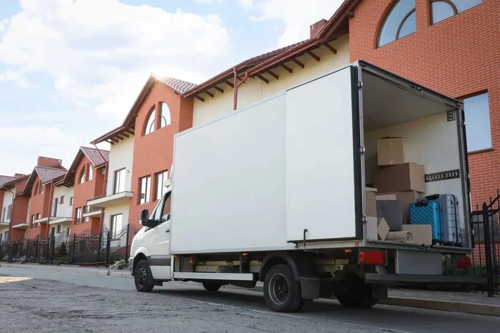 Moving truck loaded with boxes outside apartment building